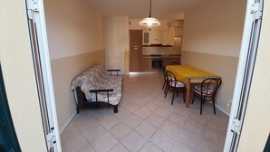 Une cuisine compacte comprenant un coin repas, un canapé et une table avec des chaises.