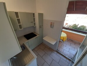 A compact kitchenette with a sink, countertop, and storage cabinets. - Sea View in Pescoluse (Marina di Pescoluse)