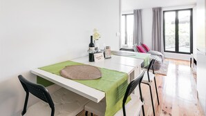 A modern, well-lit room with a dining table set for two, a bottle of wine, and a welcome sign. - GuestReady - One Step Closer (Porto)
