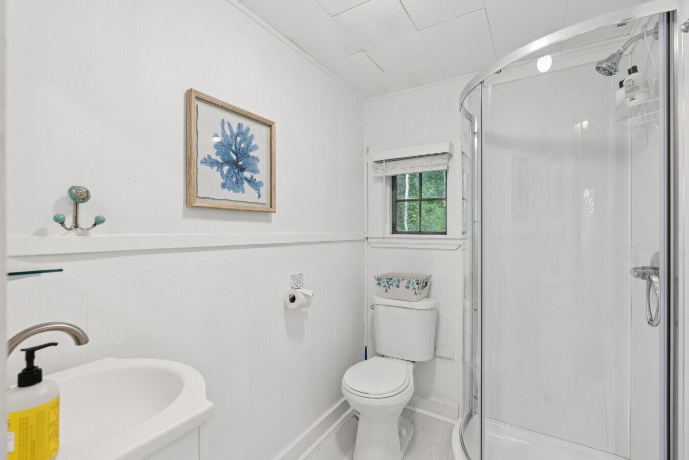 Une salle de bain avec des toilettes, un lavabo et une douche.