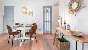 Un espace repas moderne avec une table ronde, des chaises marron et un buffet en bois.