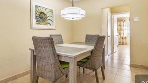 A dining area with a table and chairs, a hanging light fixture, and a framed artwork on the wall. - 5 min walk to beach on inter coastal waterway (Fort Lauderdale)