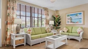 A living room with a green sofa set, a white coffee table, and a ceiling fan. - 5 min walk to beach on inter coastal waterway (Fort Lauderdale)