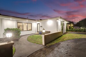 Welcome to this contemporary home with a covered porch and garage, surrounded by a beautifully landscaped garden.