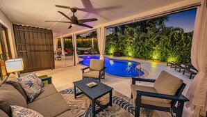 A modern outdoor living area with a pool, seating, and a ceiling fan. - Chic + Upscale + Heated Pool | 15 min FLL & Beach (Plantation)