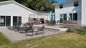A patio area with outdoor furniture, a barbecue grill, and a covered seating area. - Compound for Families- Main House with Adjacent Cottages Cabins,Indoor Pool Spa (Fennville)