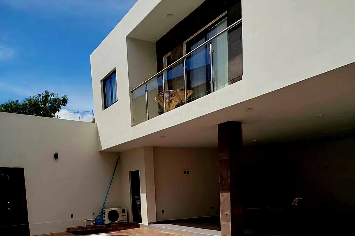A modern building with a swimming pool, a covered patio, and a large window.