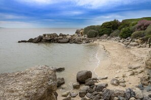 A rocky beach with a clear view of the sea and a grassy hill in the background. - Royan - APARTMENT with SEA VIEW - ONLY 300m from the BEACH and SHOPS (ROYAN)