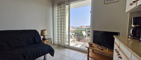 Een hotelkamer met een bed, een televisie, een koffiezetapparaat en uitzicht.