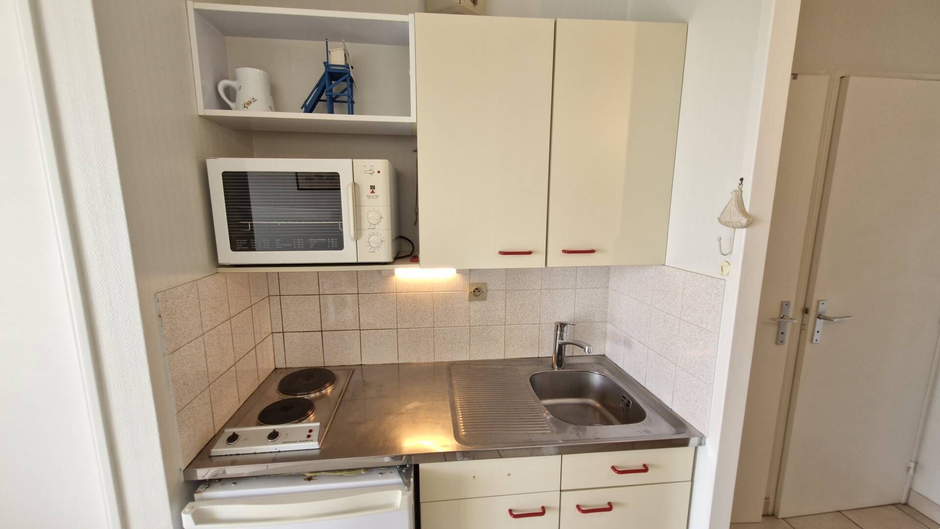 Een koelkast, kookgerei, borden en bestek