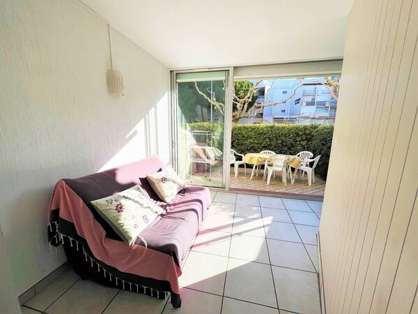 A balcony with a sofa, a table, and chairs.