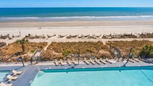 A beachside hotel with a swimming pool, sun loungers, and a view of the ocean. - Grande Beach Resort (Myrtle Beach)