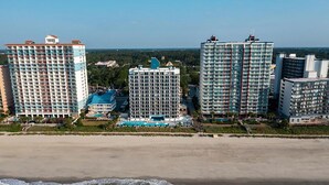 A beachfront hotel complex with multiple high-rise buildings, a pool area, and a beach in the foreground. - Grande Beach Resort (Myrtle Beach)
