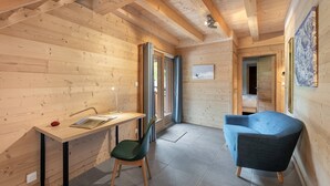 A wooden interior with a desk, chair, and blue sofa. - Duplex flat for 10 people near Lac de Vonnes (CHATEL)