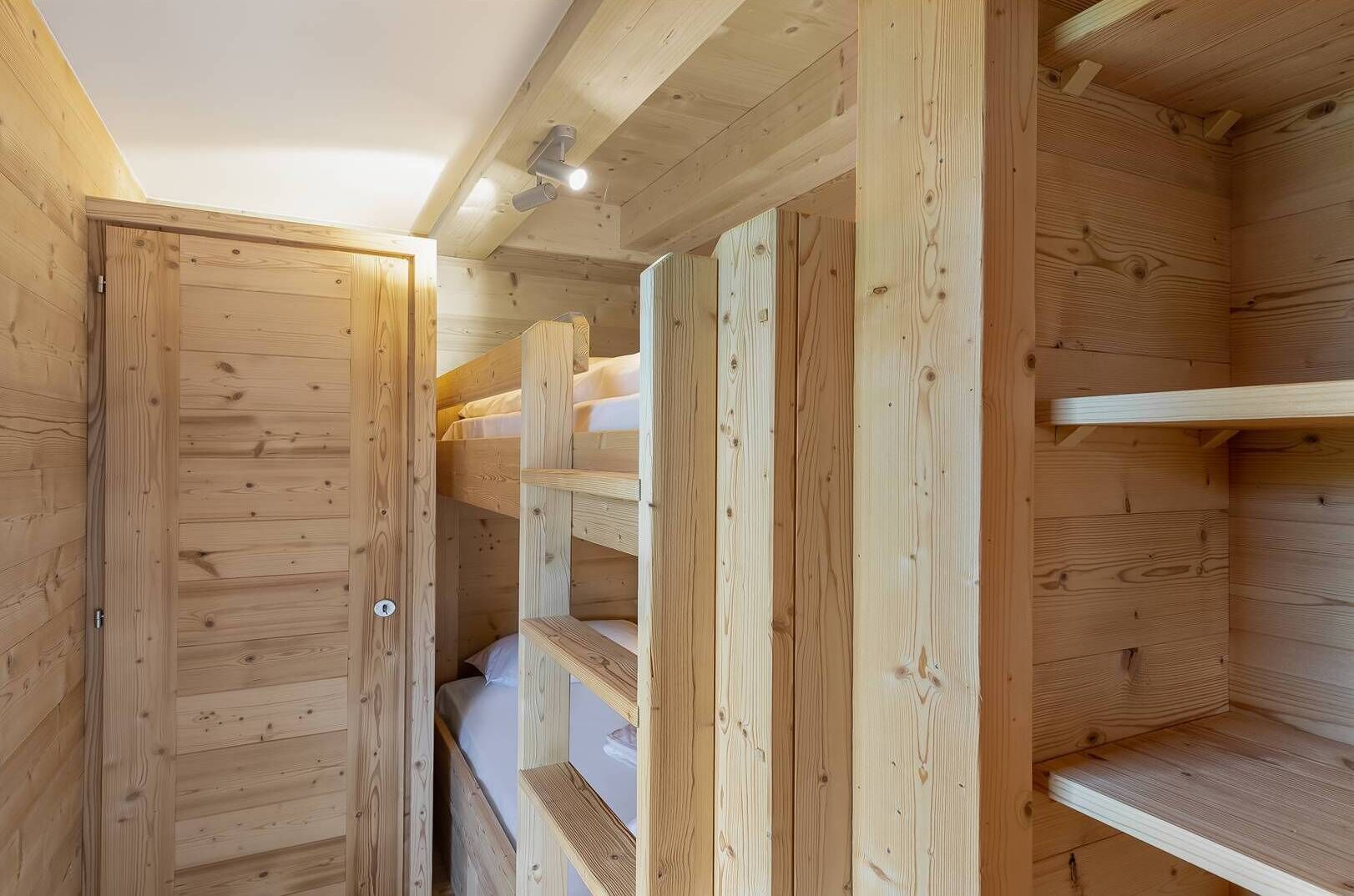 Un intérieur en bois avec des lits superposés et une porte.