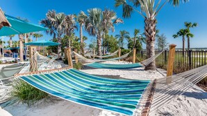 A hammock set up on a sandy beach with palm trees in the background. - Refined stay Disney Theme 8BR Resort Villa With FREE Heated Pool/Spa Near Disney (Davenport)