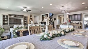 A dining area with a long table set for a meal, surrounded by wooden chairs. - A home that feels like home, w/hot tub and spacious living room (San Tan Valley)
