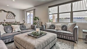 A living room with two grey sofas, a coffee table, and a large window with a view. - A home that feels like home, w/hot tub and spacious living room (San Tan Valley)