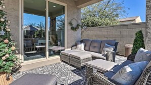 A patio with wicker furniture, a glass door leading to a dining area, and a Christmas tree. - A home that feels like home, w/hot tub and spacious living room (San Tan Valley)
