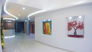 A modern hotel lobby with a curved ceiling, a reception desk, and two artworks on the walls. - HOTEL OSHO (Santa Cruz)