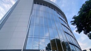A modern hotel building with a glass facade, a prominent sign for 'OSHO HOTEL', and a logo with a stylized building and tree. - HOTEL OSHO (Santa Cruz)