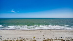 A beach with waves, a clear sky, and a few people. - Spectacular Beach Condo Double Suite for 2 couples (Myrtle Beach)