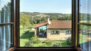 Uma casa com telhado de cerâmica, antena parabólica e piscina ao fundo.