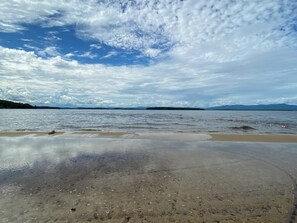 Enjoy a serene beach experience with gentle waves lapping onto the shore.