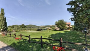 A rural property with a fenced pasture, a small building, and a hill in the background. - Lovely apartment in villa for 5 guests with pool, WIFI, TV, terrace and panoramic view (Pomarance)
