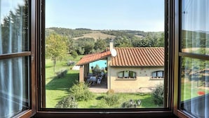 A view through a window of a house with a tiled roof, a satellite dish, and a swimming pool in the backyard. - Beautiful apartment in villa for 5 people with WIFI, pool, TV and veranda (Pomarance)