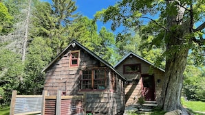 Eine rustikale Holzhütte mit Veranda und steinernen Fundament.