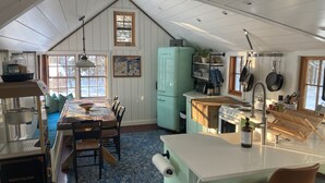 Eine gemütliche Küche mit Essbereich, Kühlschrank und diversen Küchenutensilien.