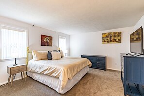 A bedroom with a bed, bedside tables, a dresser, and artwork on the walls. - Sunny Home in Private Setting (Rochester)