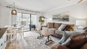 A modern living room with a sofa, coffee table, and dining area.