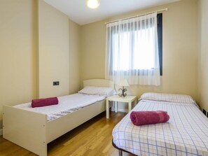 A small, clean room with two single beds, a nightstand, and a window with sheer curtains. - Porte Venere by Interhome (Moncofar)