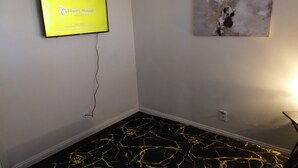 A room with a flat-screen TV mounted on the wall displaying 'Liberty Mutual Insurance'.