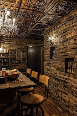 Uma zona de refeições rústica com uma mesa de madeira, cadeiras e um candelabro.