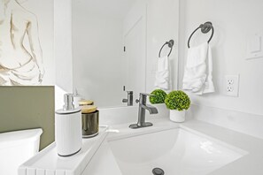 Bathtub, hair dryer, towels, toilet paper