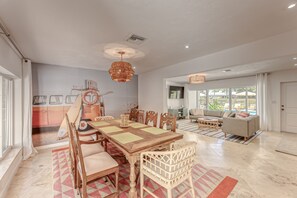 A spacious living area with a dining table, chairs, and a sofa.