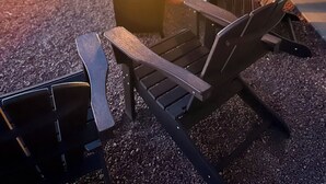 Eine Dachterrasse mit Feuerstelle und Adirondack-Sesseln.