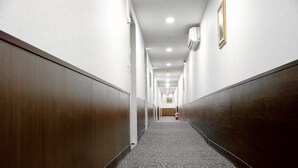 A long, narrow hallway with patterned carpet, wooden walls, and recessed lighting. - Star Ximen (Taipei)