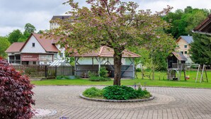 A paved courtyard with a central tree, surrounded by a brick walkway. - Apartment 'Trendelmühle Lautrach' with Garden & Wi-Fi (Lautrach)