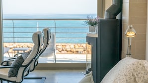 Ein Balkon mit Meerblick, einem Kamin und Sitzgelegenheiten.