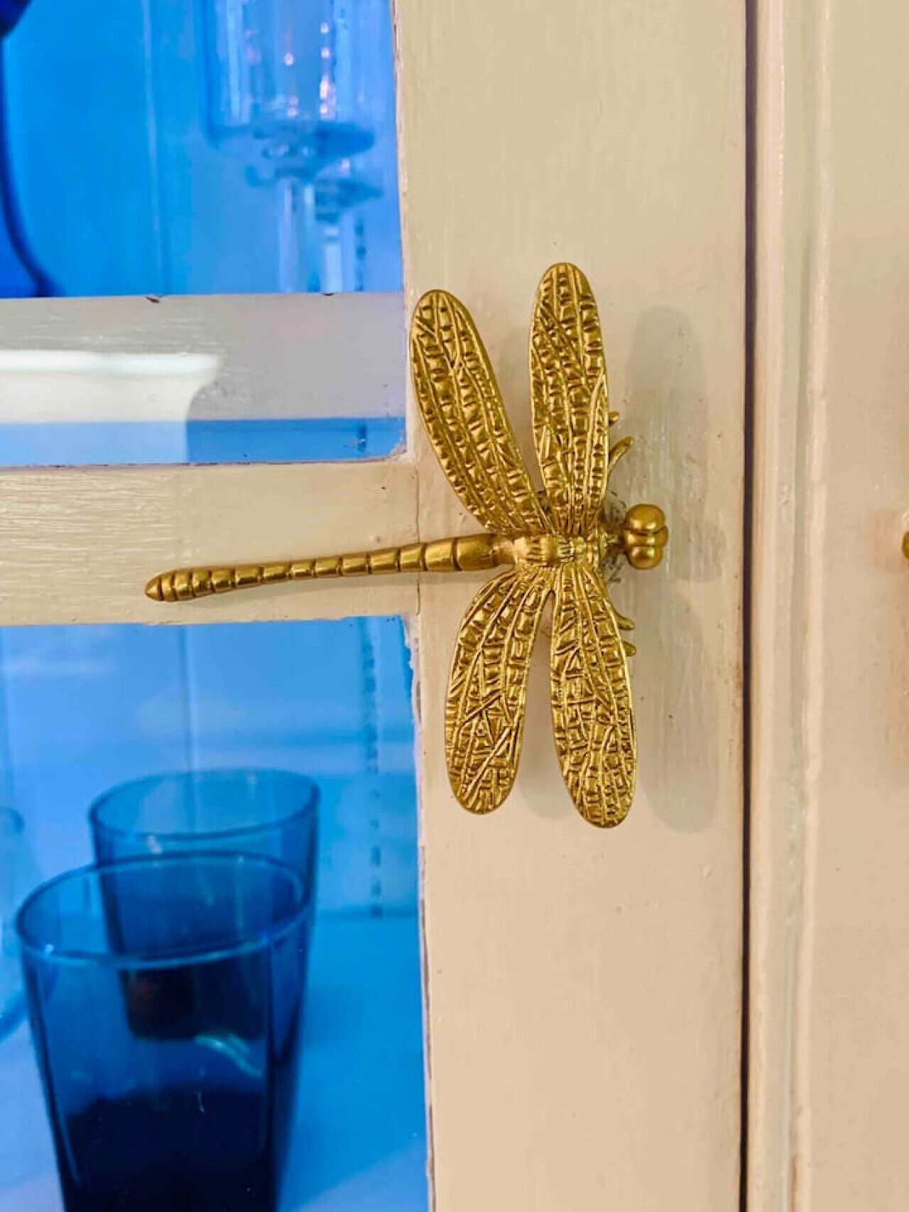 Una porta decorata con un dettagliato motivo di libellula dorata.