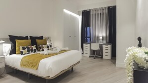 Ein modernes Schlafzimmer mit einem großen Bett, einem Schreibtisch und einem Stuhl.