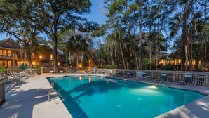 A swimming pool with lounge chairs and a building in the background.