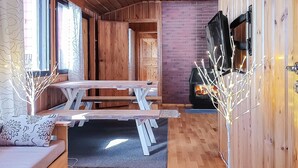 A cozy cabin interior with a wooden bench, a sofa, and a fireplace.