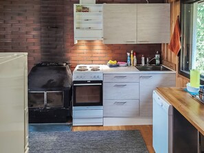 Een kleine keuken met een gasfornuis, oven en een vaatwasser.