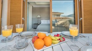 Una mesa de desayuno con fruta, vasos de jugo y cubiertos.