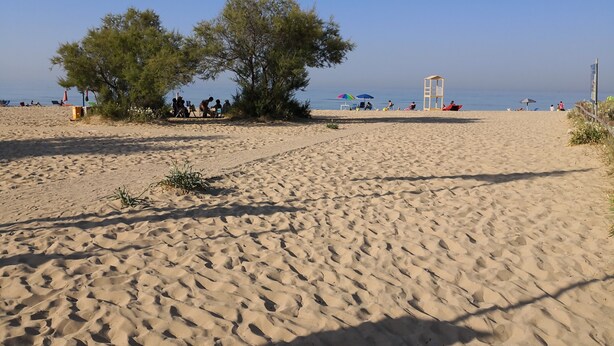 A sandy beach with a lifeguard tower, umbrellas, and people relaxing. - Blue House Torre Pali Pescoluse (SALVE)